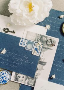 Charming flat lay of vintage stationery featuring elegant calligraphy, stamps, and a white peony flower.